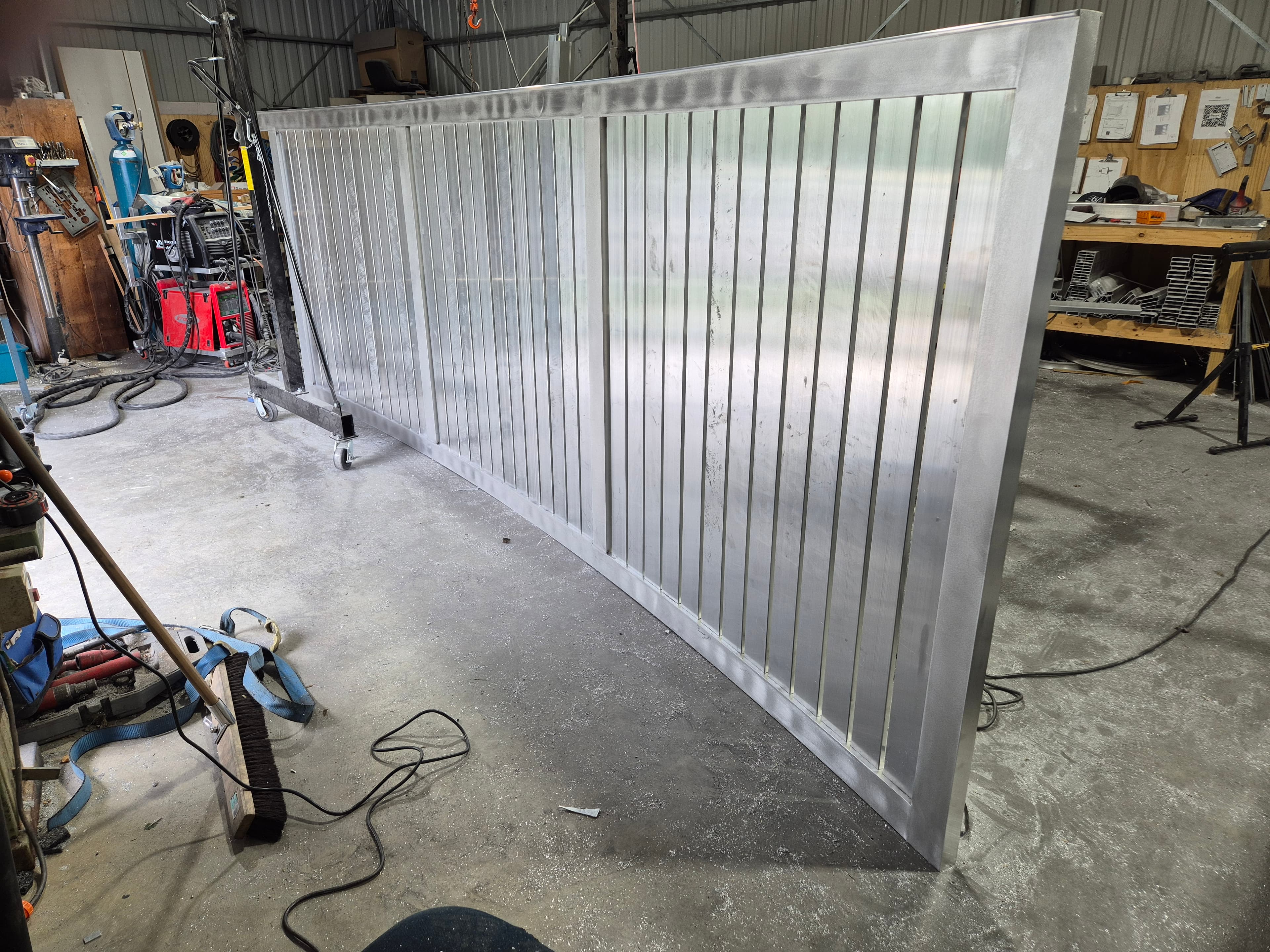 Welder in full gear fabricating a steel structure, sparks flying