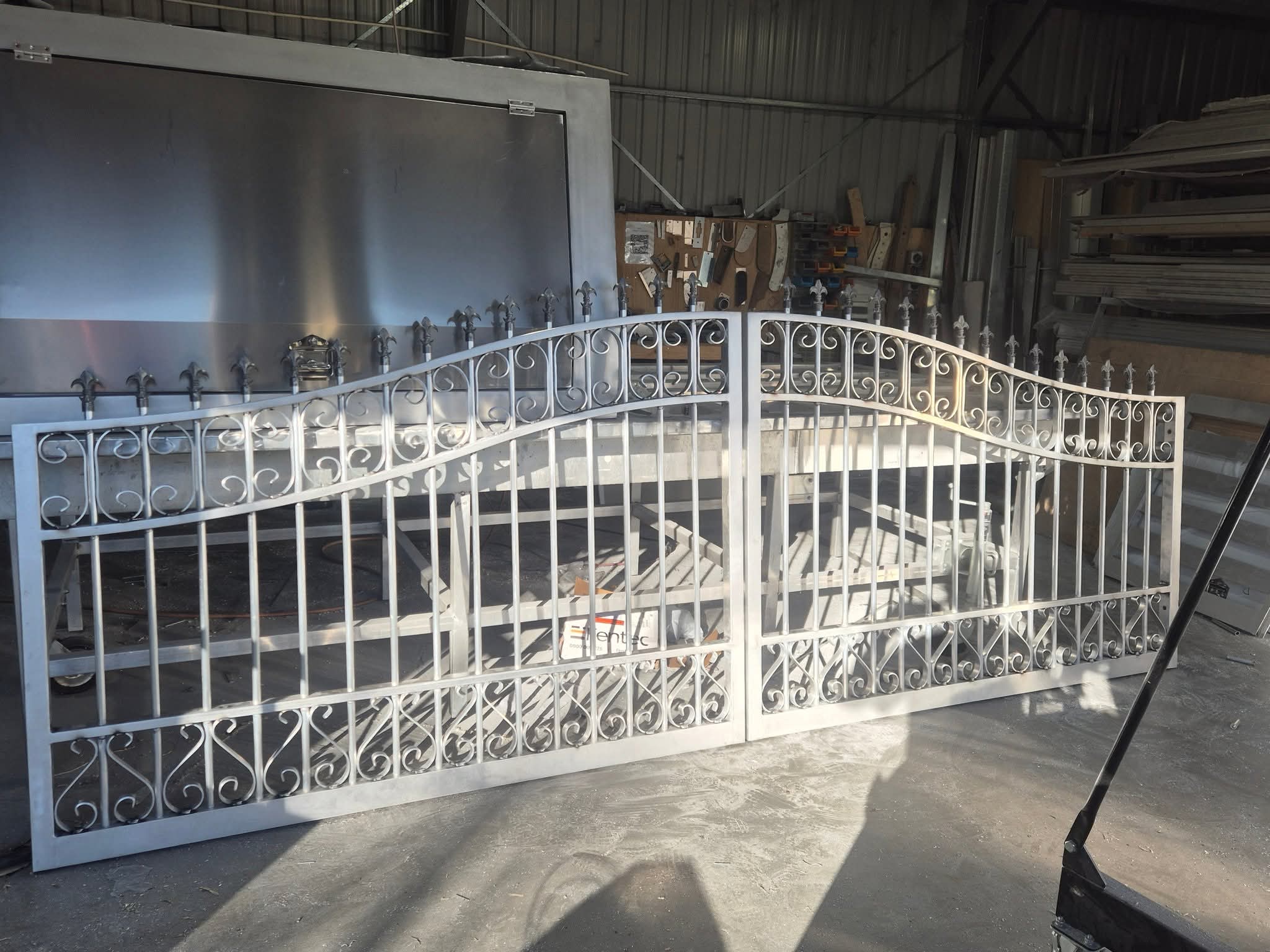 Double gate with fleur-de-lis finials under fabrication