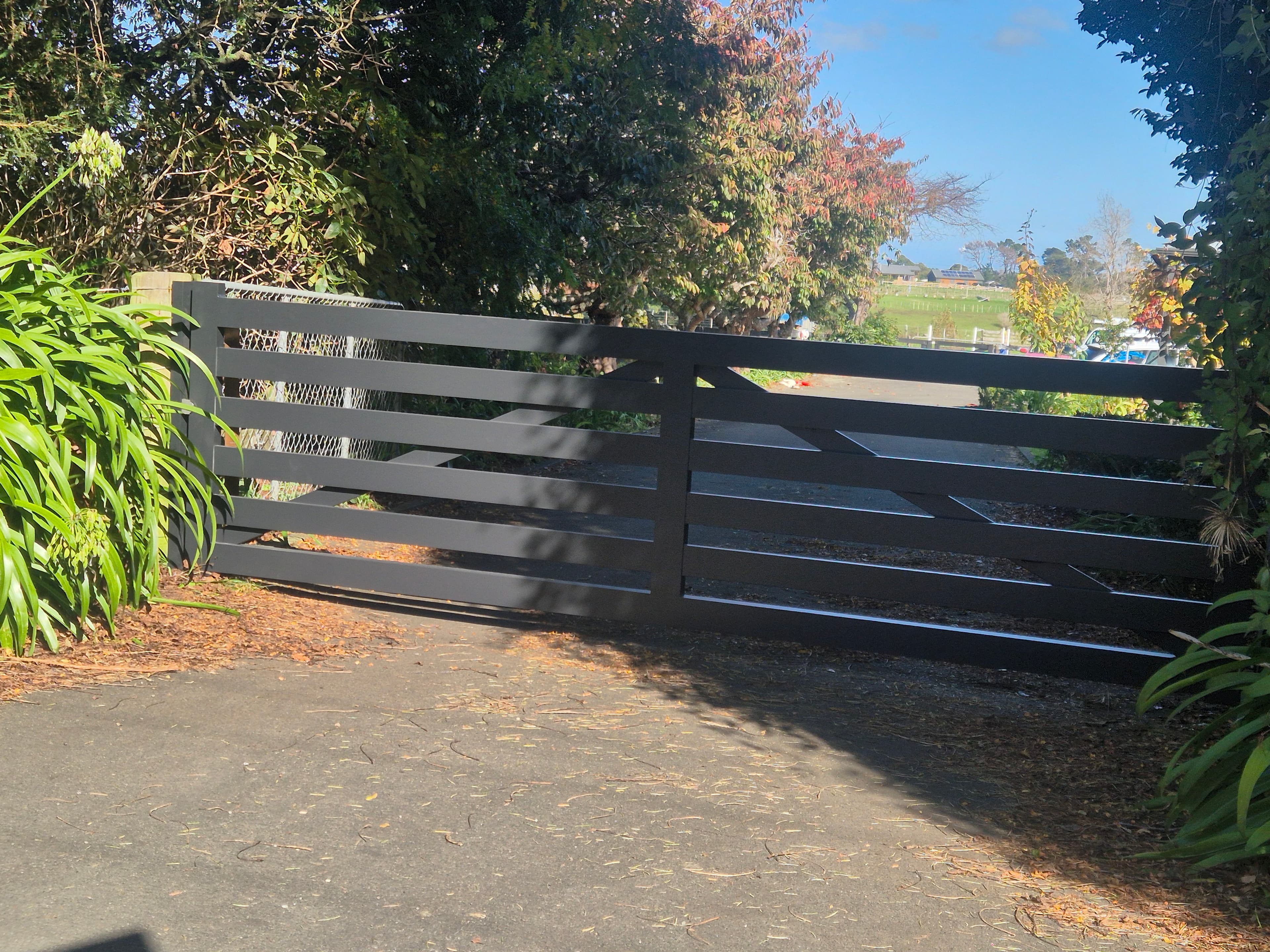 Black slat gate at a garden entrance