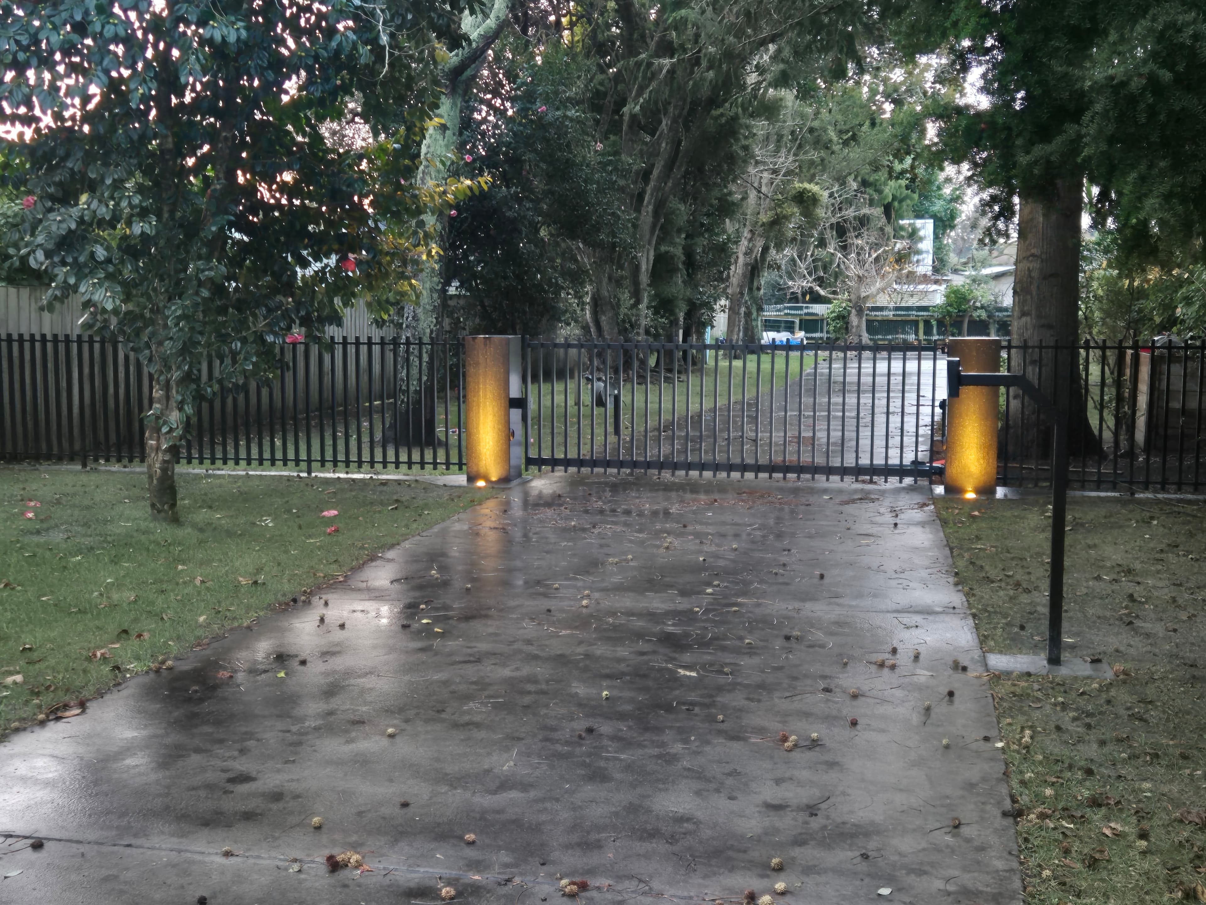 Sliding driveway gate lit up at night